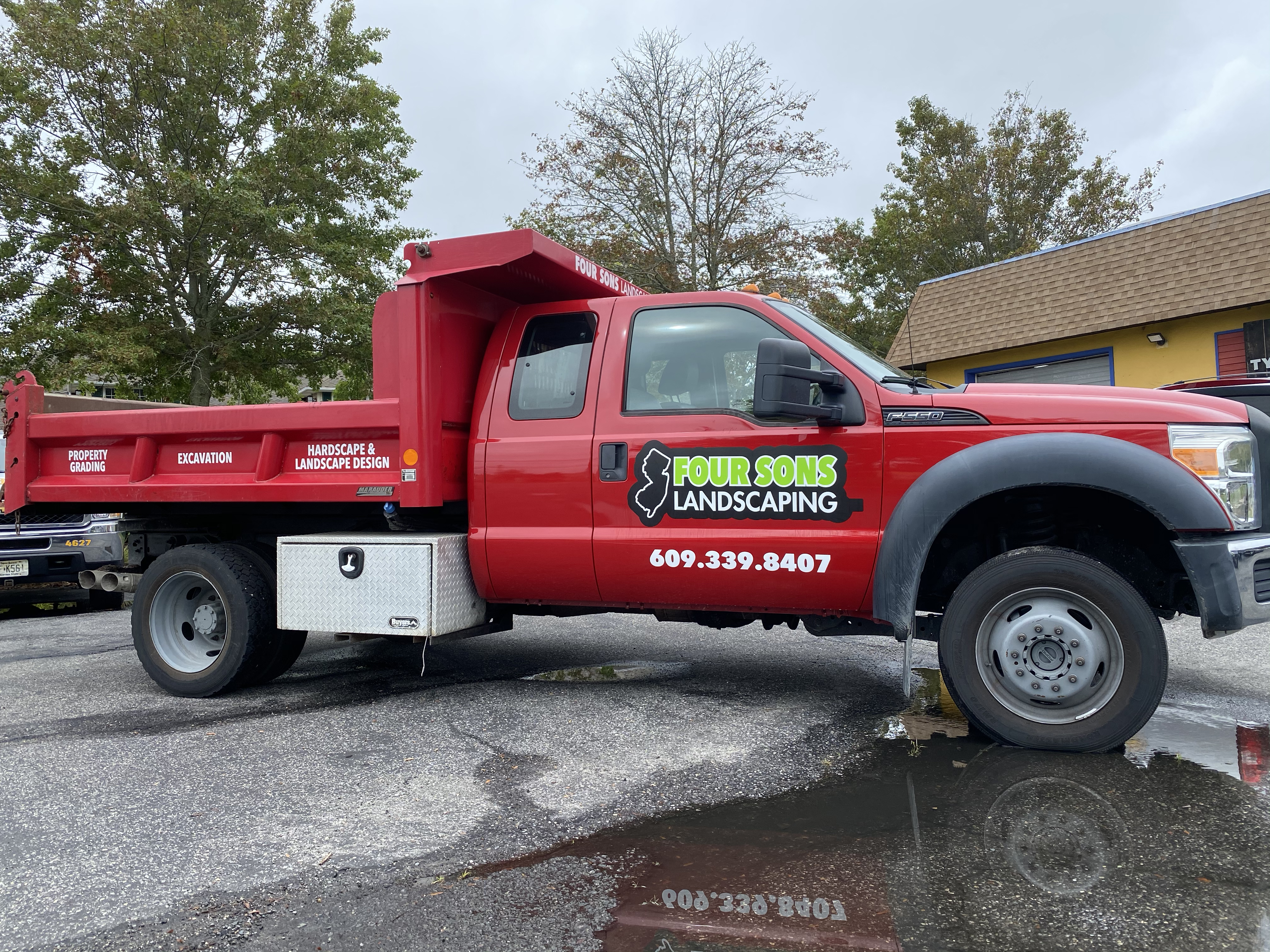Mason dump truck branding and lettering installed for Four Sons landscaping in Barnegat NJ