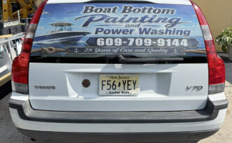 Minimalist rear-window vehicle graphics for Boat Bottom Painting & Power Washing on a Volvo SUV, featuring marine imagery, phone number and 28 Years of Care and Quality