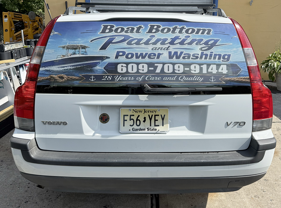 Minimalist rear-window vehicle graphics for Boat Bottom Painting & Power Washing on a Volvo SUV, featuring marine imagery, phone number and 28 Years of Care and Quality