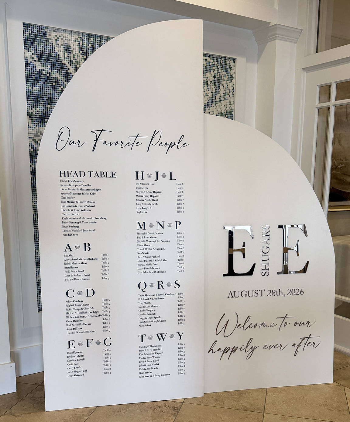 Large custom wedding seating chart and welcome display with sculptural curved panels, mirrored dimensional initials and personalized guest seating information