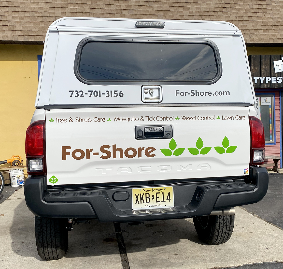 Rear three-quarter view of For-Shore Weed Control Toyota Tacoma vehicle wrap as part of a large multi-vehicle fleet branding program