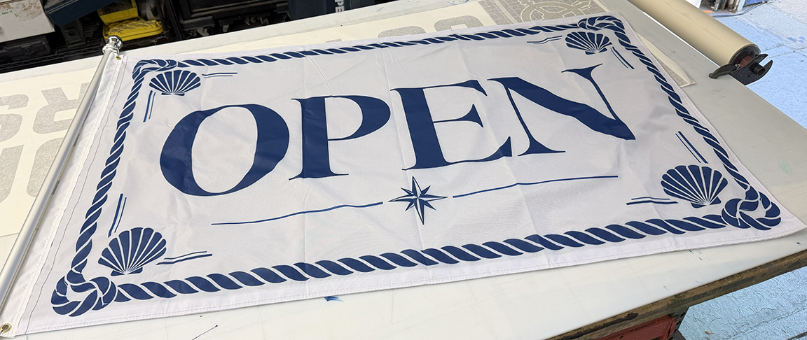 Custom double-sided OPEN business flag for Freeman & Company featuring navy coastal typography, rope border and seashell details