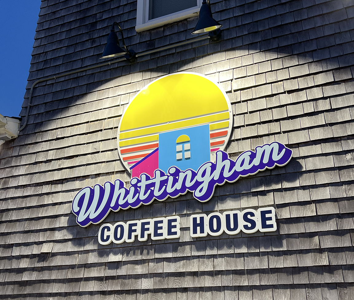 Lighted Whittingham Coffee House storefront sign in Beach Haven showing how dimensional signage and lighting create strong nighttime visibility