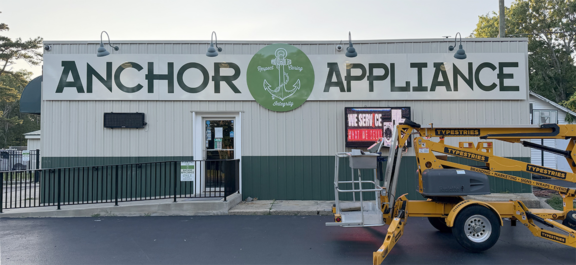 40-foot Anchor Appliance storefront sign in West Creek NJ with digitally printed graphics on aluminum composite panels installed over a corrugated metal building facade