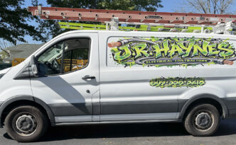Driver-side profile of white Ford Transit service van with JR Haynes Electrical Contractors graffiti-style green and black lettering and phone number