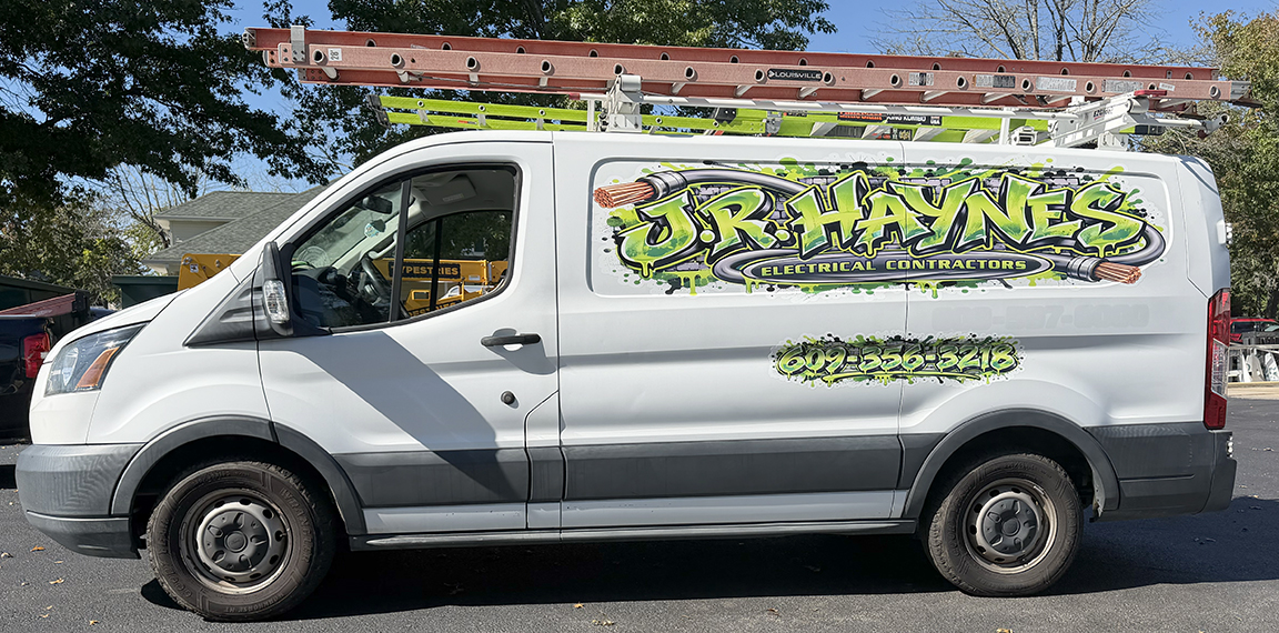 Driver-side view of JR Haynes Electrical Contractors Ford Transit with bright green graffiti-style commercial van graphics