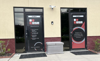 Custom black red and gray glass entry door branding graphics for O'Hara's Son Roofing office in West Creek NJ, featuring logo and service information
