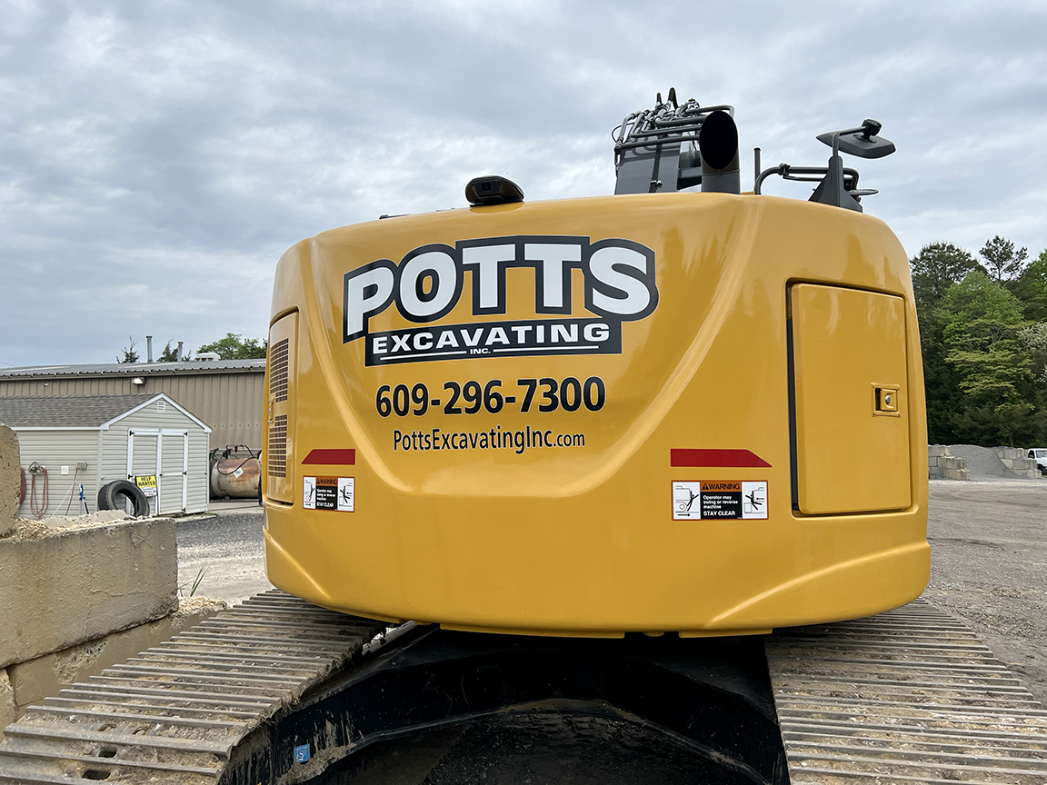 Potts Excavating excavator branded with custom printed equipment graphics for jobsite visibility in West Creek and Southern Ocean County NJ