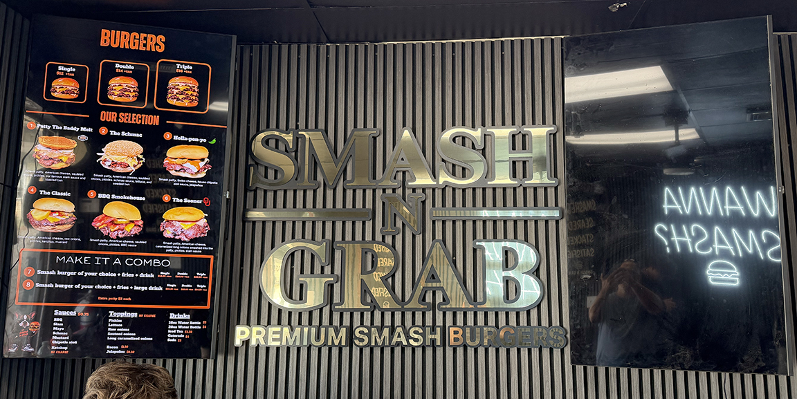 Smash N Grab restaurant interior in Manahawkin NJ featuring a raised polished gold dimensional logo, digital menu board and custom LED neon signage