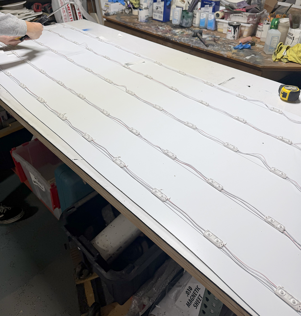 Custom LED sign cabinet retrofit panel for The Boat Shop showing evenly spaced LED modules and wiring during shop fabrication
