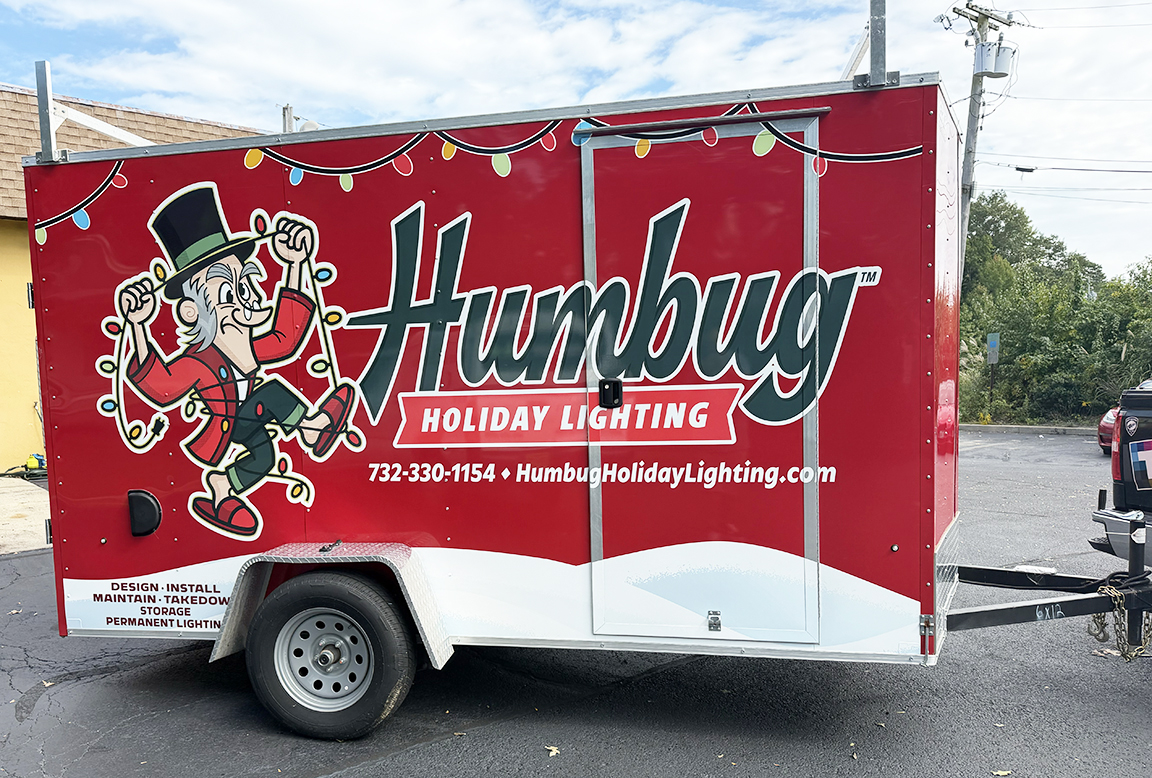 Passenger-side trailer branding wrap for Humbug Holiday Lighting, a Christmas and permanent outdoor lighting company serving Ocean County, New Jersey
